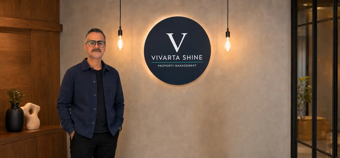 Suhail Bhatia standing beside the Vivarta Shine Property Management logo